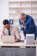 Fototapeta premium Old male boss and young male employee in bullying concept