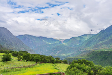 Fototapeta na wymiar Meili Snow Mountains and Grassland Pastures in Nyingchi, Tibet Autonomous Region, China on June 11, 2022