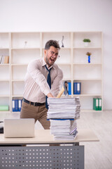 Young male employee unhappy with excessive work in the office