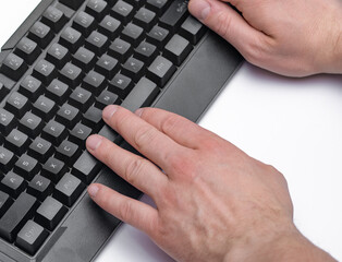 Dłonie na czarnej klawiaturze komputera na białym tle. Praca biurowa