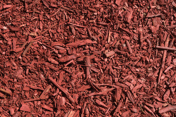 Close-up of an abstract background made of wood shavings and planks painted red.