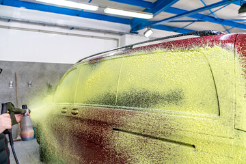 spraying cars with green foam, chemically cleaning and washing cars in the garage