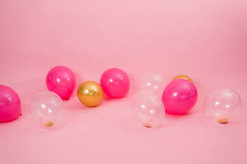 Beautiful multicolored pink, gold and transparent with confetti or sequins lie on a pink background...