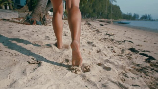 Close up legs of girl running on the beach in slow motion
