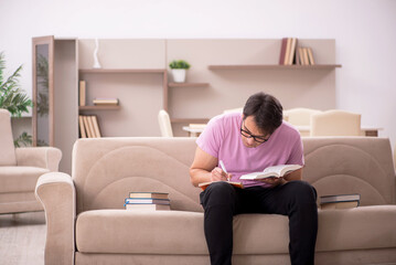 Fototapeta premium Young male student preparing for exams at home