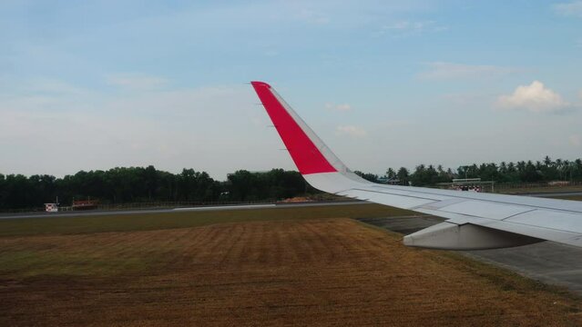View from airplane with wing on airport runway ready for takeoff in front blue cloudy sky. Passenger flight, first person view