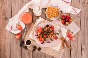 Waffles with strawberries and chocolate cream.