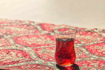 Cup of Turkish tea close up on tablecloth with turkish ornament