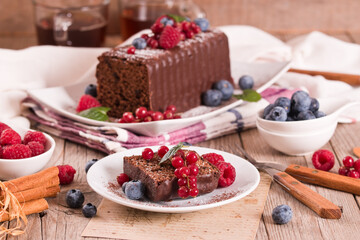 Chocolate sponge cake with fresh fruit on white dish.