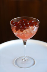 cocktail glass with strawberry bubble tea obtained with inverse spherification
