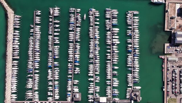 Aerial top down of docked yacht boat in a row harbor, background
