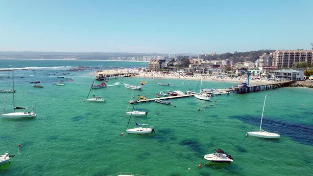 Aerial shot overhead Pejerrey beach with a tourist boat leaving with a packed beach