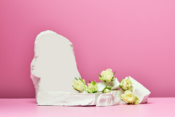 White stones and white roses isolated on pink background
