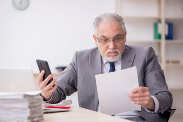 Old male employee working in the office