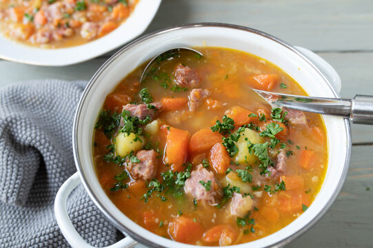 Vegetables stew with carrots, potatoes and smoked pork meat in a pot