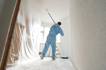 Man paints the ceiling with a roller