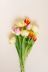 A bright spring bouquet of tulips on a beige background. Flat lay greeting card
