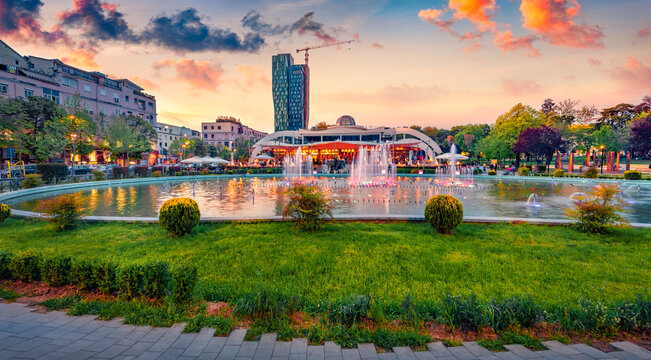 Fototapeta Wonderful spring view of Scanderbeg Square with illuminated fountain. Beautiful sunset in capital of Albania - Tirana. Traveling concept background.