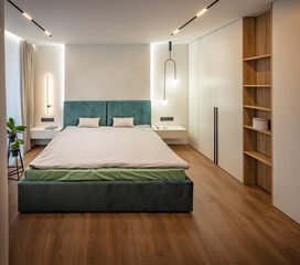 Fototapeta na wymiar Modern design of bedroom with wooden floor. Stylish interior of contemporary room with comfortable bed and wardrobe.