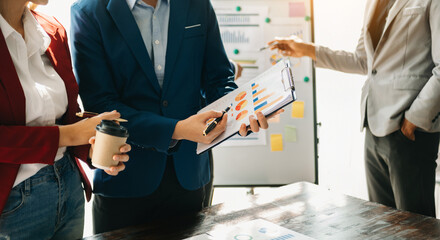 Fototapeta premium Businessman and team analyzing financial statement Finance task. with smart phone and laptop and tablet. Wealth management concept.