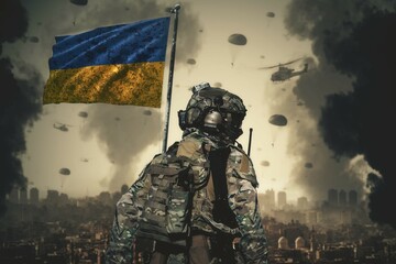 A Ukrainian soldier stands with a Ukrainian flag in his hand and looks at the ruined city