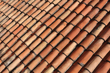 Obraz na płótnie Canvas Red and orange roof tiles texture pattern on roof of an old historical building