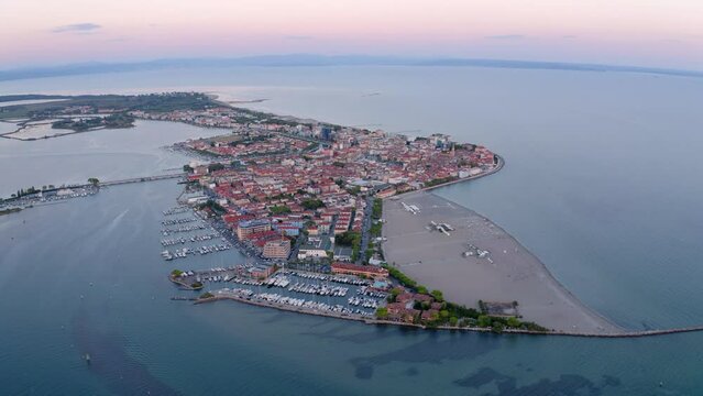 4k drone flight moving to the side footage (Ultra High Definition) of public beach of Grado port, small town located between Venice and Trieste. Magnificent evening seascape of Adriatic sea.