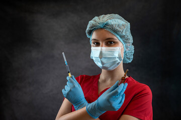 Woman doctor in red medical coat holds a syringe for injections against coronavirus isolated