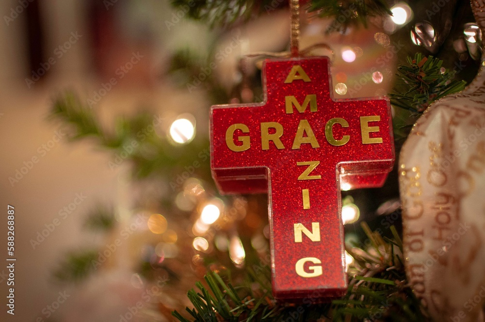 Poster shallow focus of a red cross with amazing grace text with blur background