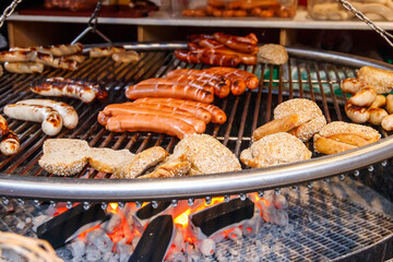 Grilling delicious juicy meat sausages on a big grill