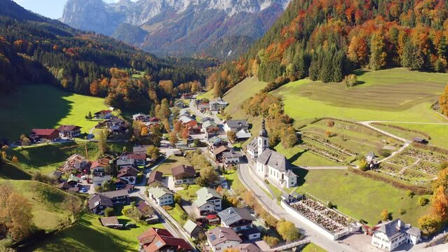 4k drone up and forward video (Ultra High Definition) of Parish Church of St. Sebastian. Colorful autumn view of Bavarian Alps, Ramsau bei Berchtesgaden village.