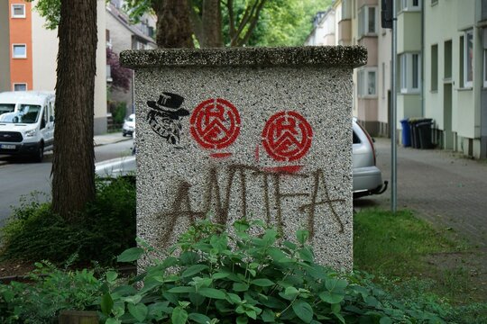 Closeup of an electricity box with graffiti of RWE Rot-Weiss-Essen football and Antifa in Germany