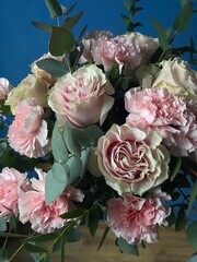 Beautiful bouquet of fresh pink roses and fluffy carnations with green eucalyptus