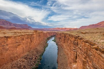 A stunning view of a rugged canyon featuring steep vertical walls of rock that form a deep
