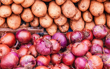 Organic potatoes and dry onions for sale at the local market. Vegan food background.