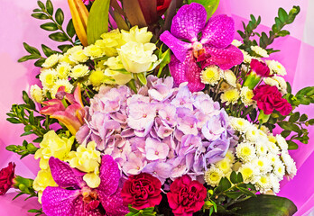 close-up of a beautiful bouquet with orchids, roses, phlox, aist and other flowers. horizontal