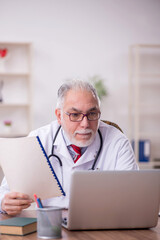 Fototapeta premium Old male doctor in telemedicine concept