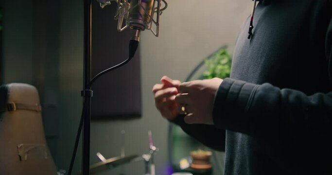 HD of an East Asian male singing in recording studio. United States