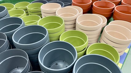 Close-up of empty flower pots in a store or greenhouse. Colorful pots for plants. Gardening and landscape design concept - obrazy, fototapety, plakaty