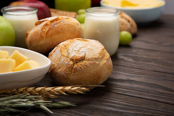 Jewish Shavuot Holiday Card. Dairy Products, Fruits, Cheese, Bread, Milk on Brown Wooden Background.