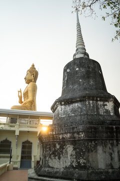 Image of Lord Buddha  of gold Buddha statue with pagoda that Buddhist show to worship with reflect sunlight background at Wat Khao Ban Dai It, Phetchaburi, Thailand.