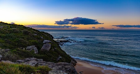 Aerial view of a sunset sky over a rocky seashore in Sydney, Australia