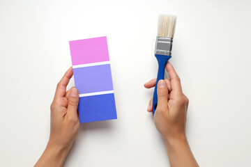 Female hands holding color palette and brush on white background