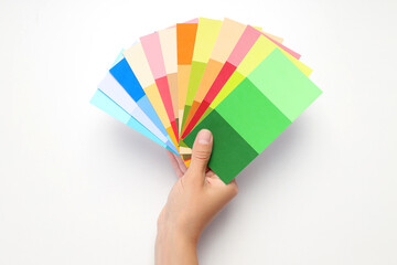 Female hand holding color palettes on white background