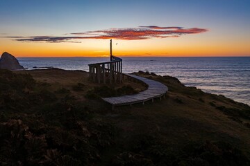 Beautiful shot of a wooden walking path with the background of the ocean during a sunset