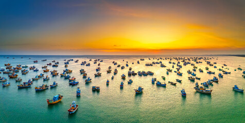 Aerial view of Mui Ne fishing village in sunset sky with hundreds of boats anchored to avoid storms, this is a beautiful bay in central Vietnam