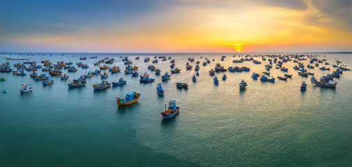 Aerial view of Mui Ne fishing village in sunset sky with hundreds of boats anchored to avoid...