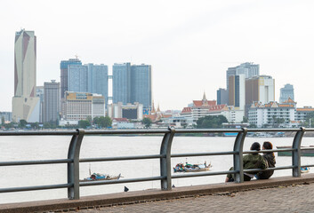 Cambodian people looking across the Tonle Sap river,towards Phnom Penh's City skyline,Cambodia.
