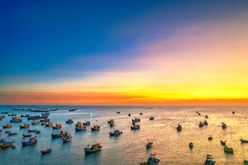 Aerial view of Mui Ne fishing village in sunset sky with hundreds of boats anchored to avoid...