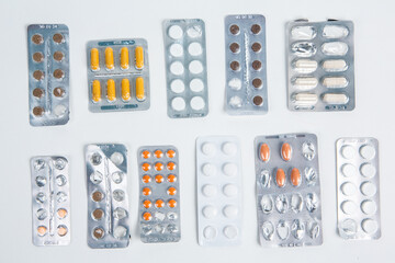 Pills in blister pack on white background. Tablets and capsules in blister packs. Top view, copy space.